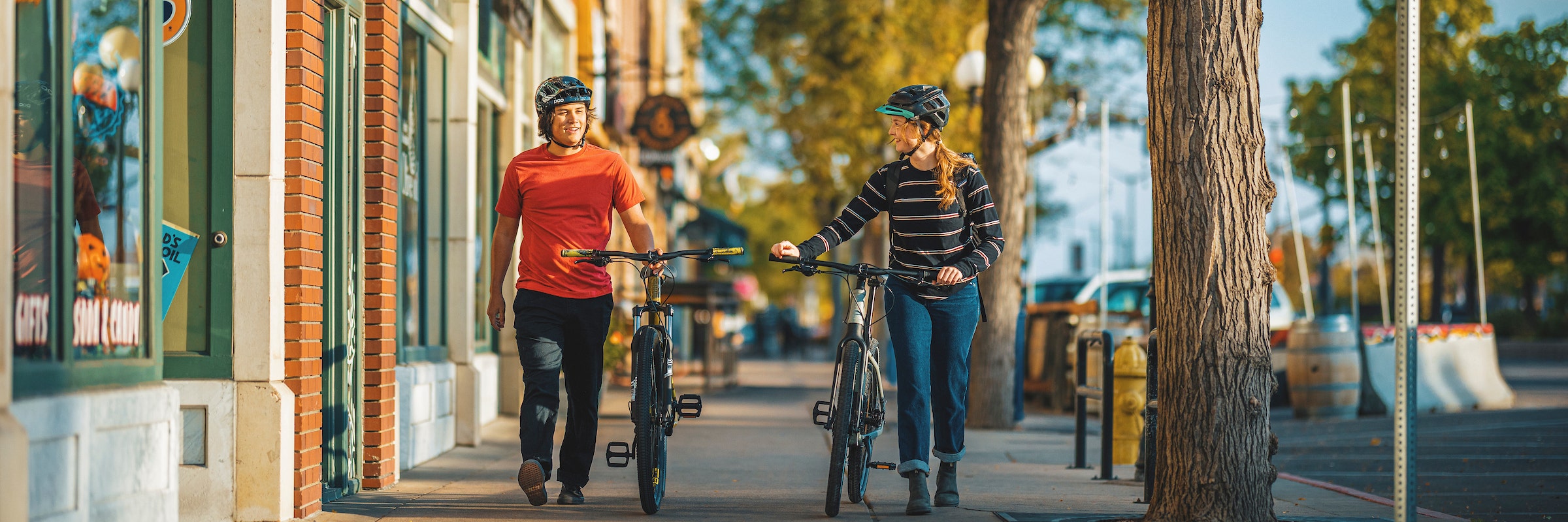Magasins avec des cyclistes qui marchent des vélos par lots sur le trottoir